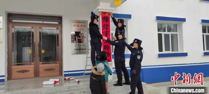 圖為恩和哈達(dá)邊境派出所民警貼對(duì)聯(lián)?！《骱凸_(dá)邊境派出所供圖